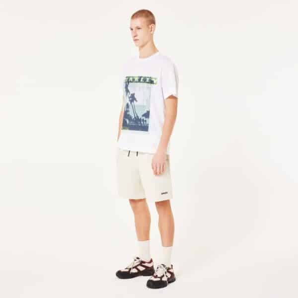 חולצה קצרה אוקלי לבן OAKLEY PALM TEE דוגמן מקדימה ידיים לצד הגוף מסתכל ימינה